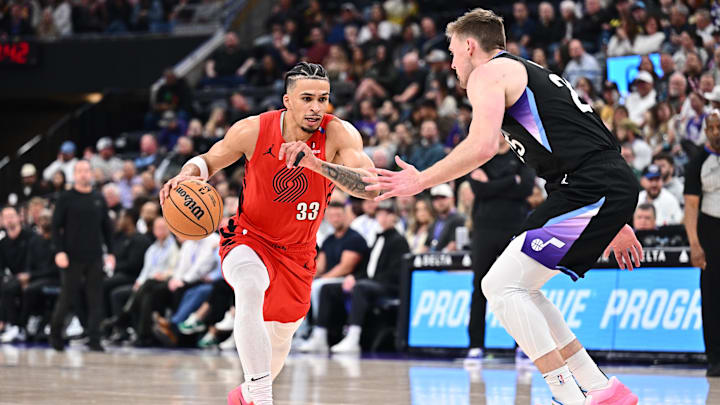 Apr 9, 2025; Salt Lake City, Utah, USA;  Portland Trail Blazers forward Toumani Camara (33) controls the ball while being guarded by Utah Jazz center Micah Potter (25) in the second half at Delta Center. Mandatory Credit: Jamie Sabau-Imagn Images