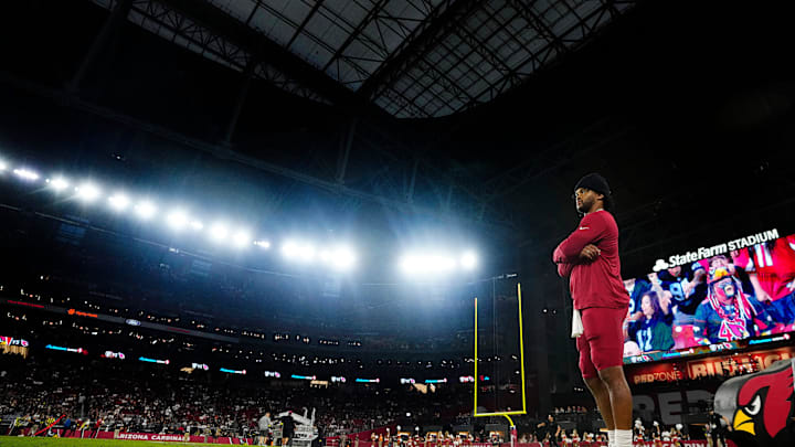 Cardinals quarterback Kyler Murray gets wired up on the sidelines during a preseason game against the Raiders at State Farm Stadium in Glendale on Aug. 23, 2025.