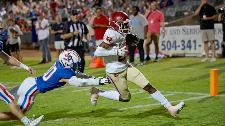 Oct 27, 2023; Metairie, LA, USA; Brother Martin Crusaders wide receiver Easton Royal (23) scores a touchdown against John Curtis Patriots linebacker Benjamin Barron (30) during the first quarter at The Shrine on Airline. Mandatory Credit: Matthew Hinton-Imagn Images