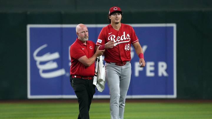 Aug 21, 2026; Phoenix, Arizona, USA; Cincinnati Reds first baseman Michael Toglia (48) leaves the trainer after diving foe a ball against the Arizona Diamondbacks in the first inning at Chase Field. Mandatory Credit: Rick Scuteri-Imagn Images Aug 21, 2026; Phoenix, Arizona, USA; Cincinnati Reds first baseman Michael Toglia (48) leaves the trainer after diving foe a ball against the Arizona Diamondbacks in the first inning at Chase Field. Mandatory Credit: Rick Scuteri-Imagn Images