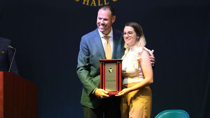 West Virginia University Director of Athletics Wren Baker presenting rifle All-American Petra Zublasing with the WVU Hall of Fame plaque