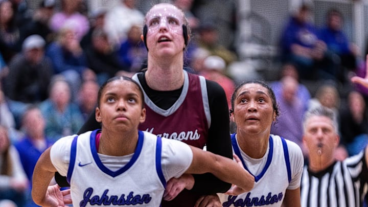 Johnston's Adaya Phillips (20), Dowling’s Ellie Muller (23) and Johnston's Jenica Lewis (10) look to the basket after a pair of Dowling free throws on Dec. 16, 2025, at Johnston High School.