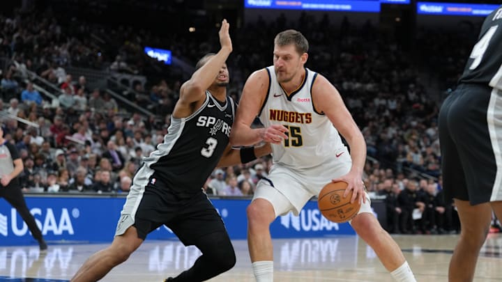 Mar 12, 2026; San Antonio, Texas, USA;  Denver Nuggets center Nikola Jokic (15) dribbles against San Antonio Spurs forward Keldon Johnson (3) in the first half at Frost Bank Center. Mandatory Credit: Daniel Dunn-Imagn Images