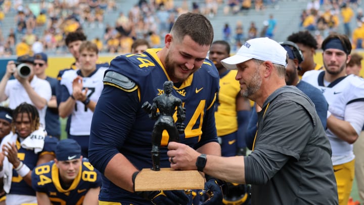 West Virginia offensive lineman Wyatt Milum receives the Iron Mountaineer award from strength and conditioning coach Mike Joseph West Virginia offensive lineman Wyatt Milum receives the Iron Mountaineer award from strength and conditioning coach Mike Joseph