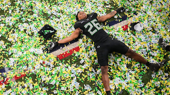 Oregon Ducks linebacker Devon Jackson (26) makes a confetti angel on Sunday, Dec. 8, 2024, after the Big Ten Championship game at Lucas Oil Stadium in Indianapolis. The Oregon Ducks defeated the Penn State Nittany Lions, 45-37.