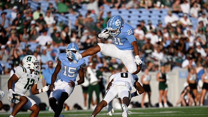Sep 7, 2024; Chapel Hill, North Carolina, USA; North Carolina Tar Heels running back Davion Gause (21) jumps over Charlotte 49ers defensive back Al-Ma'hi Ali (0) in the fourth quarter at Kenan Memorial Stadium. Mandatory Credit: Bob Donnan-Imagn Images