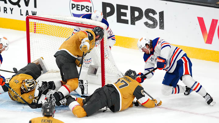 Edmonton Oilers right wing Kasperi Kapanen (42) digs the puck out from under the skate of Vegas Golden Knights goaltender Adin Hill (33) to score a game-winning goal in overtime to give the Oilers a 1-0 victory in the game and a 4-1 series win during game five of the second round of the 2025 Stanley Cup Playoffs at T-Mobile Arena. 