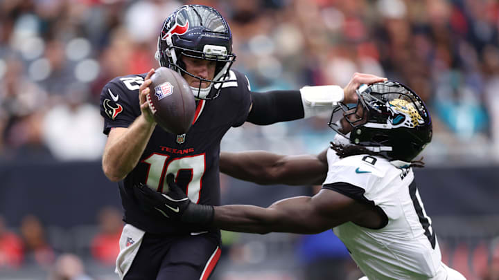 Nov 9, 2025; Houston, Texas, USA; Houston Texans quarterback Davis Mills (10) is pressured by Jacksonville Jaguars linebacker Devin Lloyd (0) during the first half at NRG Stadium. Mandatory Credit: Troy Taormina-Imagn Images