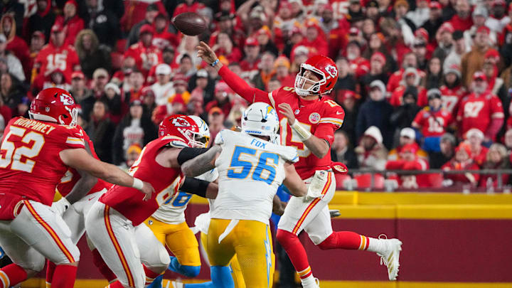 Dec 8, 2024; Kansas City, Missouri, USA; Kansas City Chiefs quarterback Patrick Mahomes (15) leaps while passing as Los Angeles Chargers defensive end Morgan Fox (56) defends during the second half at GEHA Field at Arrowhead Stadium. Mandatory Credit: Denny Medley-Imagn Images