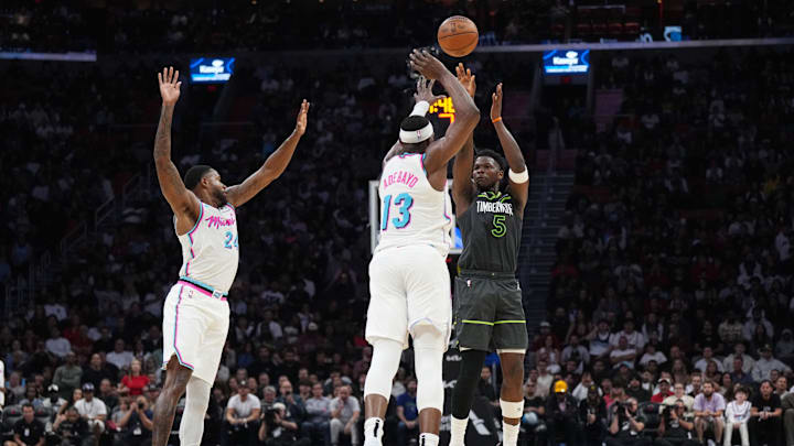 Mar 7, 2025; Miami, Florida, USA;  Minnesota Timberwolves guard Anthony Edwards (5) shoots over Miami Heat center Bam Adebayo (13) as forward Haywood Highsmith (24) closes in during the second half at Kaseya Center. Mandatory Credit: Jim Rassol-Imagn Images