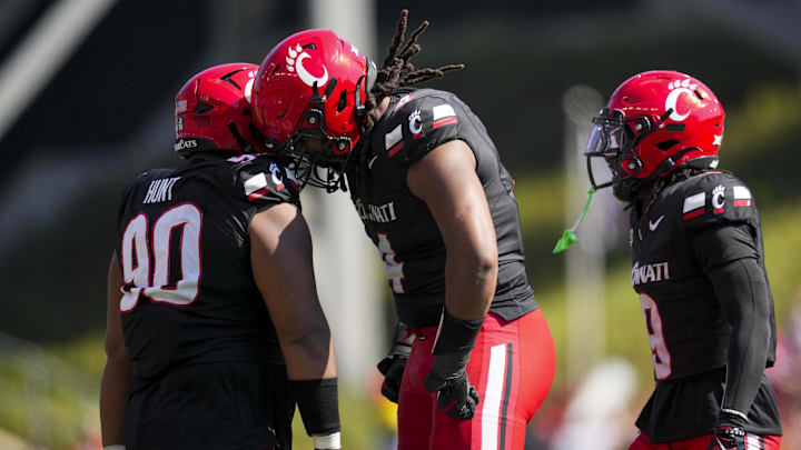 Oct 4, 2025; Cincinnati, Ohio, USA;  Cincinnati Bearcats defensive lineman Jalen Hunt (90), defensive end Mikah Coleman (4), and defensive back Jiquan Sanks (9) celebrate after a play against the Iowa State Cyclones in the first half at Nippert Stadium. Mandatory Credit: Aaron Doster-Imagn Images