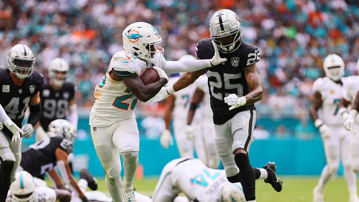 Miami Dolphins running back De'Von Achane (28) puts a stiff arm against Las Vegas Raiders cornerback Decamerion Richardson (25) during the third quarter at Hard Rock Stadium in a 2024 game. Miami Dolphins running back De'Von Achane (28) puts a stiff arm against Las Vegas Raiders cornerback Decamerion Richardson (25) during the third quarter at Hard Rock Stadium in a 2024 game.