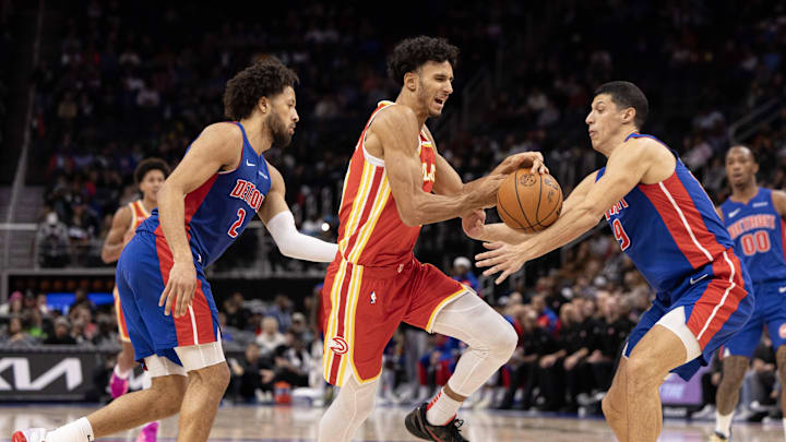 Nov 8, 2024; Detroit, Michigan, USA; Atlanta Hawks forward Zaccharie Risacher (10) moves the ball up court between Detroit Pistons guard Cade Cunningham (2) and forward Simone Fontecchio (19) during the first half at Little Caesars Arena. Mandatory Credit: David Reginek-Imagn Images