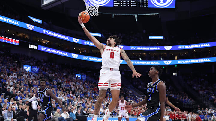 Nov 21, 2025; Salt Lake City, Utah, USA; Wisconsin Badgers guard Braeden Carrington (0) lays the ball up against BYU Cougars forward AJ Dybantsa (3) during the first half at Delta Center. 