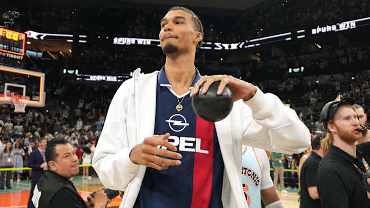 Apr 13, 2025; San Antonio, Texas, USA; San Antonio Spurs center Victor Wembanyama (1) prepares to throw a ball in to the stands in celebration of Fan Appreciation Day after a victory over the Toronto Raptors at Frost Bank Center. Mandatory Credit: Scott Wachter-Imagn Images
