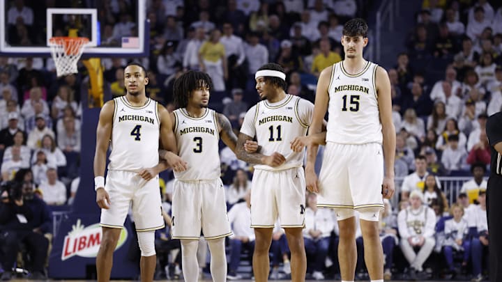 Feb 14, 2026; Ann Arbor, Michigan, USA; Michigan Wolverines guard Nimari Burnett (4) guard Elliot Cadeau (3) guard Roddy Gayle Jr. (11) and center Aday Mara (15) lock arms during the first half against the UCLA Bruins at Crisler Center. Mandatory Credit: Rick Osentoski-Imagn Images