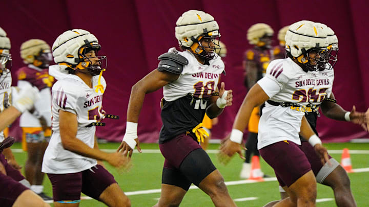 Arizona State linebacker Martell Hughes (18, center) warms up with his teammates during a practice inside the Verde Dickey Dome in Tempe on August 12, 2025.