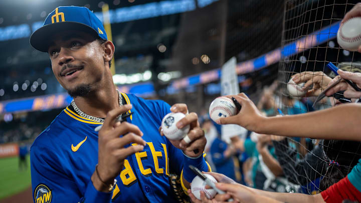 Seattle Mariners centerfielder Julio Rodriguez (44) signs autographs for fans before a game against the Texas Rangers at T-Mobile Park in 2024.