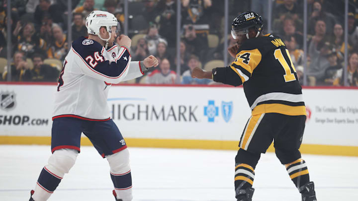 Mar 21, 2025; Pittsburgh, Pennsylvania, USA;  Pittsburgh Penguins left wing Bokondji Imama (14) and Columbus Blue Jackets right wing Mathieu Olivier (24) fight during the first period at PPG Paints Arena. Mandatory Credit: Charles LeClaire-Imagn Images