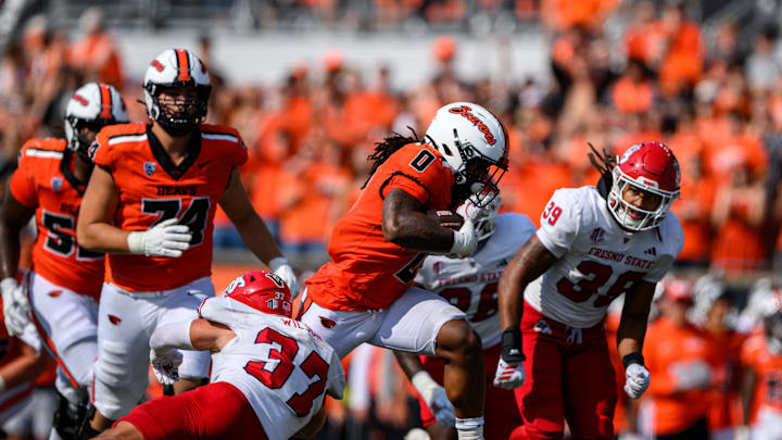 Sep 6, 2025; Corvallis, Oregon, USA; Oregon State Beavers running back Anthony Hankerson (0) runs the ball between Fresno State Bulldogs defensive back Ryan Wilson (37) and linebacker Jadon Pearson (39) during the fourth quarter at Reser Stadium. Mandatory Credit: Craig Strobeck-Imagn Images
