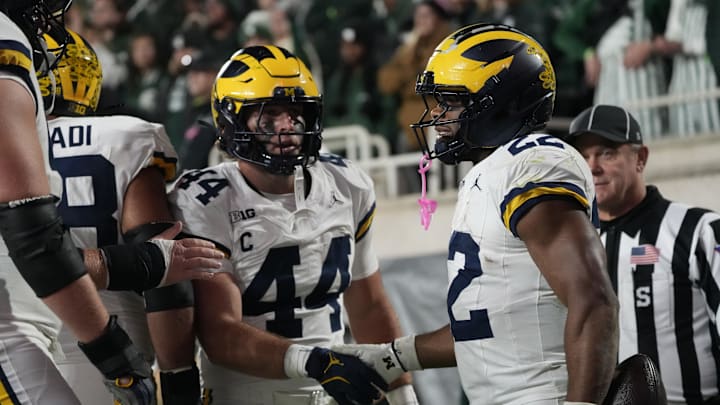 Oct 25, 2025; East Lansing, Michigan, USA; Michigan Wolverines running back Justice Haynes (22) reacts with tight end Max Bredeson (44) after scoring a touchdown against the Michigan Wolverines during the second half at Spartan Stadium. Mandatory Credit: Brendan Mullin-Imagn Images
