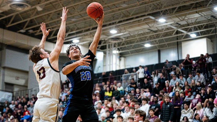 Waukee Northwest's Isaiah Oliver (20) looks to take a shot over Dowling Catholic's Maddox Coppola (13) on Friday, Feb. 7, 2025, at Dowling Catholic High School.