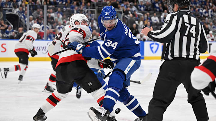 Apr 22, 2025; Toronto, Ontario, CAN;  Toronto Maple Leafs forward Auston Matthews (34) battles for the puck with Ottawa Senators forward Shane Pinto (12) in the third period in game two of the first round of the 2025 Stanley Cup Playoffs at Scotiabank Arena. Mandatory Credit: Dan Hamilton-Imagn Images