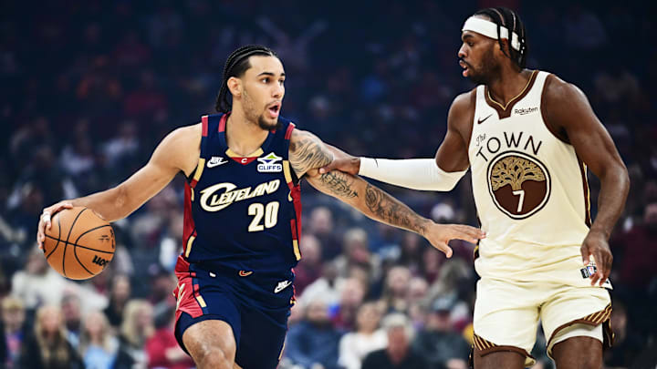 Dec 6, 2025; Cleveland, Ohio, USA; Cleveland Cavaliers guard Jaylon Tyson (20) brings the ball up court against Golden State Warriors guard Buddy Hield (7) during the first half at Rocket Arena. Mandatory Credit: Ken Blaze-Imagn Images