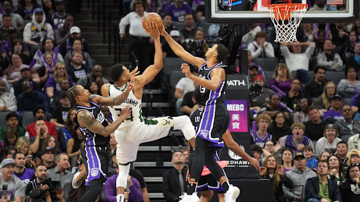 Mar 22, 2025; Sacramento, California, USA; Sacramento Kings forward Keegan Murray (right) blocks a shot by Milwaukee Bucks forward Giannis Antetokounmpo (center) as forward DeMar DeRozan (left) defends during the fourth quarter at Golden 1 Center. Mandatory Credit: Darren Yamashita-Imagn Images