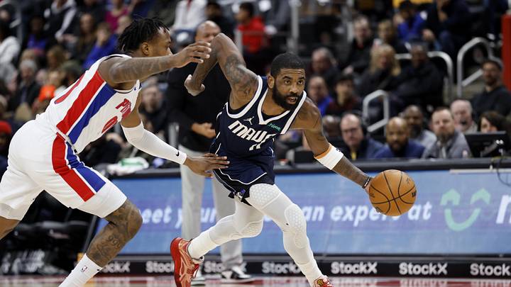Jan 31, 2025; Detroit, Michigan, USA;  Dallas Mavericks guard Kyrie Irving (11) dribbles on Detroit Pistons forward Ronald Holland II (00) in the first half at Little Caesars Arena. Mandatory Credit: Rick Osentoski-Imagn Images
