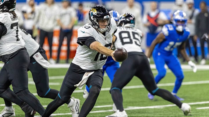 Nov 17, 2024; Detroit, Michigan, USA; Jacksonville Jaguars quarterback Mac Jones (10) hands off the ball to against the Detroit Lions during the second half at Ford Field. Mandatory Credit: David Reginek-Imagn Images
