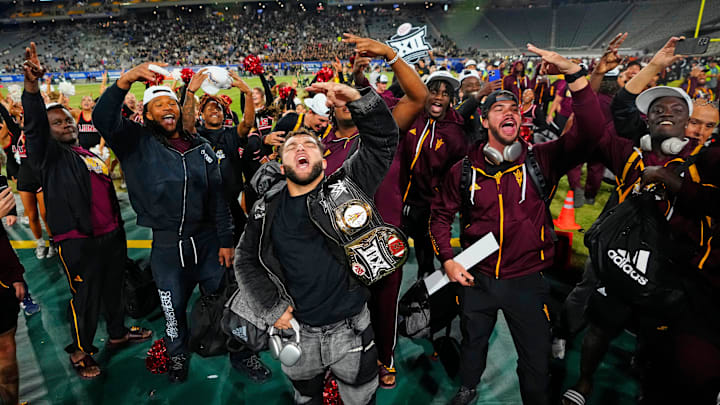 ASU runningback Cam Skattebo arrives to the sidelines wearing the Big 12 Championship belt around his arm after the team won the Big 12 Championship earlier in the day against Iowa State. The team was greeted by fans of the Open State Championship.