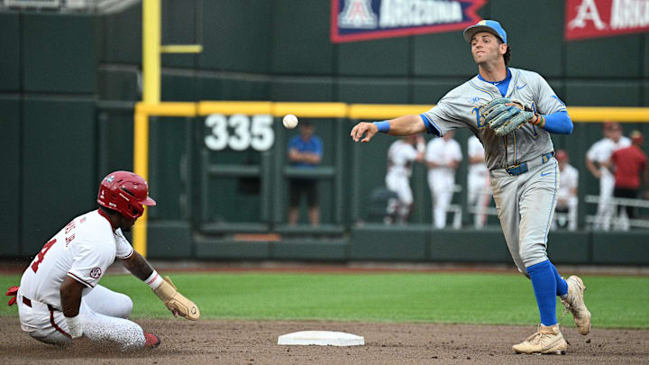 Jun 17, 2025; Omaha, Neb, USA; UCLA Bruins shortstop Roch Cholowsky (1) completes a double play after getting Arkansas Razorbacks center fielder Justin Thomas Jr. (4) out during the fifth inning at Charles Schwab Field. Mandatory Credit: Steven Branscombe-Imagn Images Jun 17, 2025; Omaha, Neb, USA; UCLA Bruins shortstop Roch Cholowsky (1) completes a double play after getting Arkansas Razorbacks center fielder Justin Thomas Jr. (4) out during the fifth inning at Charles Schwab Field. Mandatory Credit: Steven Branscombe-Imagn Images