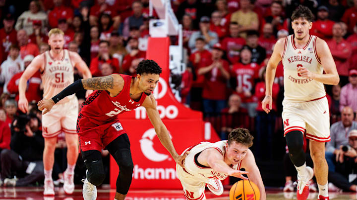 Dec 10, 2025; Lincoln, Nebraska, USA; Nebraska Cornhuskers forward Pryce Sandfort (21) dives for the ball against Wisconsin Badgers guard Nick Boyd (2) during the first half at Pinnacle Bank Arena. Mandatory Credit: Dylan Widger-Imagn Images Dec 10, 2025; Lincoln, Nebraska, USA; Nebraska Cornhuskers forward Pryce Sandfort (21) dives for the ball against Wisconsin Badgers guard Nick Boyd (2) during the first half at Pinnacle Bank Arena. Mandatory Credit: Dylan Widger-Imagn Images