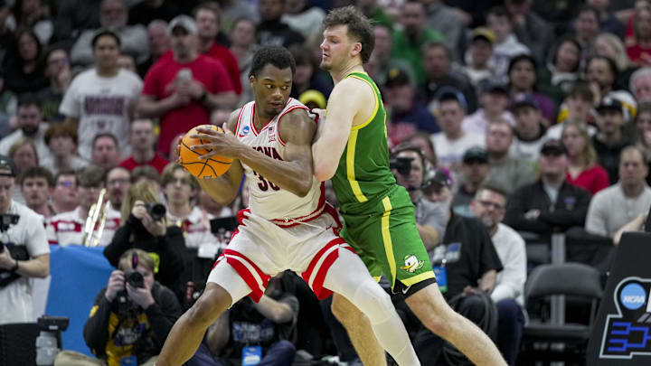 Mar 23, 2025; Seattle, WA, USA;  Arizona Wildcats forward Tobe Awaka (30) dribbles the ball against Oregon Ducks center Nate Bittle (32) in the second half at Climate Pledge Arena. Mandatory Credit: Stephen Brashear-Imagn Images