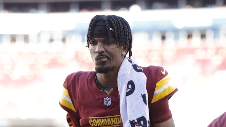 Oct 20, 2024; Landover, Maryland, USA; Washington Commanders quarterback Jayden Daniels (5) walks off the field during the first quarter after an injury against the Carolina Panthers at Northwest Stadium. Mandatory Credit: Amber Searls-Imagn Images