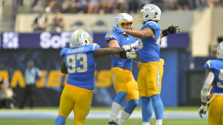 Sep 8, 2024; Inglewood, California, USA;  Los Angeles Chargers linebacker Joey Bosa (97) celebrates with defensive tackle Otito Ogbonnia (93) and linebacker Tuli Tuipulotu (45) after forcing a fumble in the second half against the Las Vegas Raiders at SoFi Stadium. Mandatory Credit: Jayne Kamin-Oncea-Imagn Images
