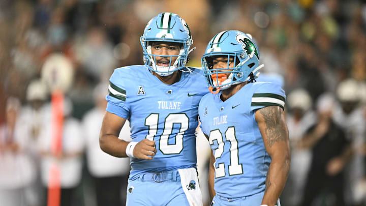 Tulane Green Wave players Darian Mensah (10) and Makhi Hughes (21) talk to each other. Tulane Green Wave players Darian Mensah (10) and Makhi Hughes (21) talk to each other.