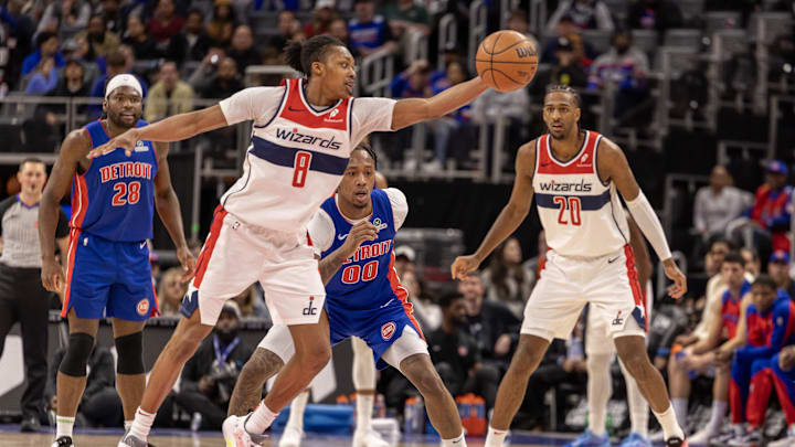 Mar 11, 2025; Detroit, Michigan, USA; Washington Wizards guard Bub Carrington (8) reaches for a pass in front of Detroit Pistons forward Ronald Holland II (00) during the second half at Little Caesars Arena. Mandatory Credit: David Reginek-Imagn Images