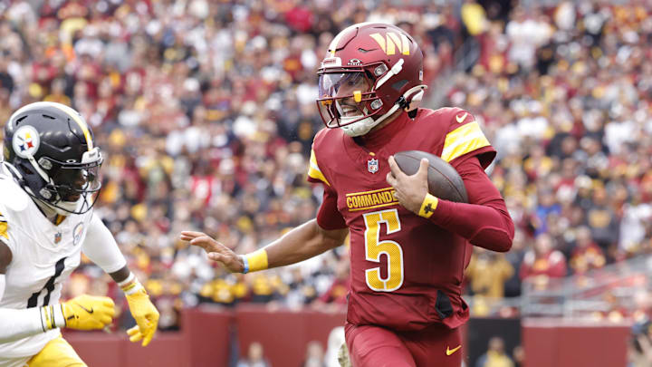Nov 10, 2024; Landover, Maryland, USA; Washington Commanders quarterback Jayden Daniels (5) carries the ball as Pittsburgh Steelers linebacker Patrick Queen (6) defends during the first half at Northwest Stadium. Mandatory Credit: Amber Searls-Imagn Images