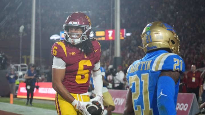 Nov 29, 2025; Los Angeles, California, USA; Southern California Trojans wide receiver Makai Lemon (6) catches a 32-yard touchdown pass against UCLA Bruins defensive back Kanye Clark (1) in the second half at United Airlines Field at Los Angeles Memorial Coliseum. Mandatory Credit: Kirby Lee-Imagn Images