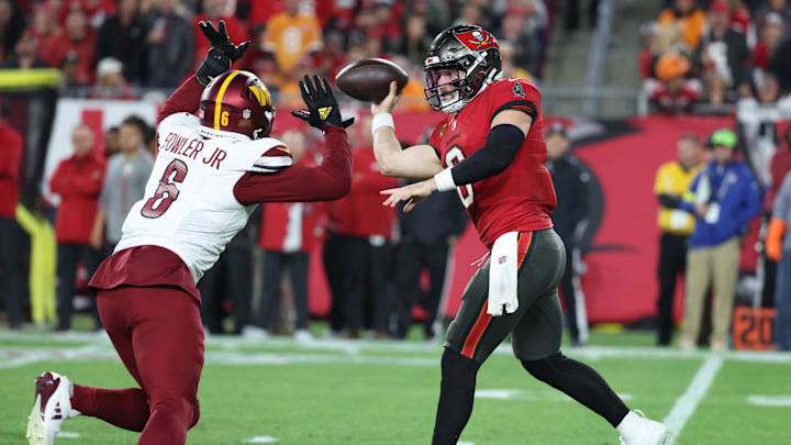 Jan 12, 2025; Tampa, Florida, USA; Tampa Bay Buccaneers quarterback Baker Mayfield (6) throws against Washington Commanders linebacker Dante Fowler Jr. (6)  during the third quarter of a NFC wild card playoff at Raymond James Stadium. Mandatory Credit: Kim Klement Neitzel-Imagn Images