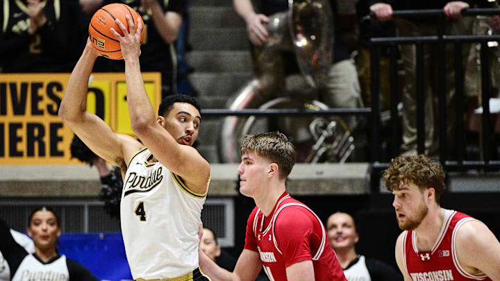 Feb 15, 2025; West Lafayette, Indiana, USA; Purdue Boilermakers forward Trey Kaufman-Renn (4) keeps the ball away from Wisconsin Badgers forward Nolan Winter (31) during the first half at Mackey Arena. Mandatory Credit: Marc Lebryk-Imagn Images