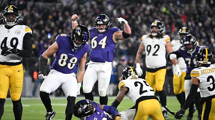 Jan 11, 2025; Baltimore, Maryland, USA; Baltimore Ravens running back Derrick Henry (22) celebrates with tight end Charlie Kolar (88) and center Tyler Linderbaum (64) after scoring a touchdown against Pittsburgh Steelers safety DeShon Elliott (25) in the second quarter in an AFC wild card game at M&T Bank Stadium. Mandatory Credit: Tommy Gilligan-Imagn Images