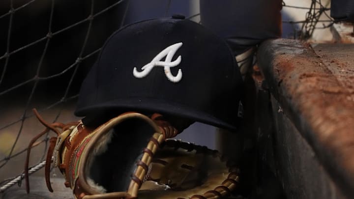 Aug 13, 2022; Miami, Florida, USA; A general view of the cap and glove of Atlanta Braves first baseman Matt Olson (28) on the dugout steps in the ninth inning against the Miami Marlins at loanDepot park. Mandatory Credit: Jasen Vinlove-Imagn Images