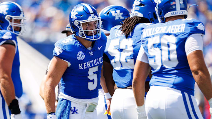 Aug 30, 2025; Lexington, Kentucky, USA; Kentucky Wildcats quarterback Zach Calzada (5) talks with offensive lineman Alex Wollschlaeger (50) during the first quarter against the Toledo Rockets at Kroger Field. Mandatory Credit: Jordan Prather-Imagn Images