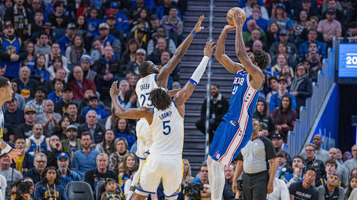 Mar 24, 2023; San Francisco, California, USA;  Golden State Warriors forward Draymond Green (23) defends against Philadelphia 76ers center Joel Embiid (21) during the fourth quarter at Chase Center. Mandatory Credit: Neville E. Guard-Imagn Images