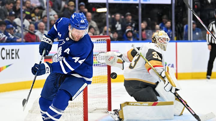 Feb 27, 2024; Toronto, Ontario, CAN;  Toronto Maple Leafs defenseman Morgan Rielly (44) chases the puck after a save and rebound from Vegas Golden Knights goalie Adin Hill (33) in the third period at Scotiabank Arena. Mandatory Credit: Dan Hamilton-Imagn Images