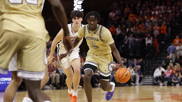 Feb 8, 2025; Charlottesville, Virginia, USA; Georgia Tech Yellow Jackets forward Baye Ndongo (11) dribbles the ball past Virginia Cavaliers forward Blake Buchanan (0) during the first half at John Paul Jones Arena. Mandatory Credit: Amber Searls-Imagn Images