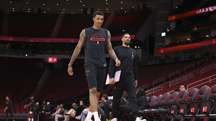 Jan 13, 2026; Houston, Texas, USA; Houston Rockets forward Jabari Smith Jr. (left) walks on the court with assistant coach Garrett Jackson before the game against the Chicago Bulls at Toyota Center. Mandatory Credit: Troy Taormina-Imagn Images